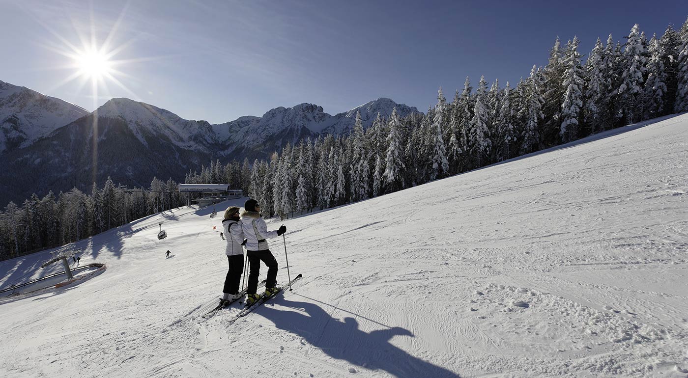 Zwei Skifahrer stehen am Pistenrand