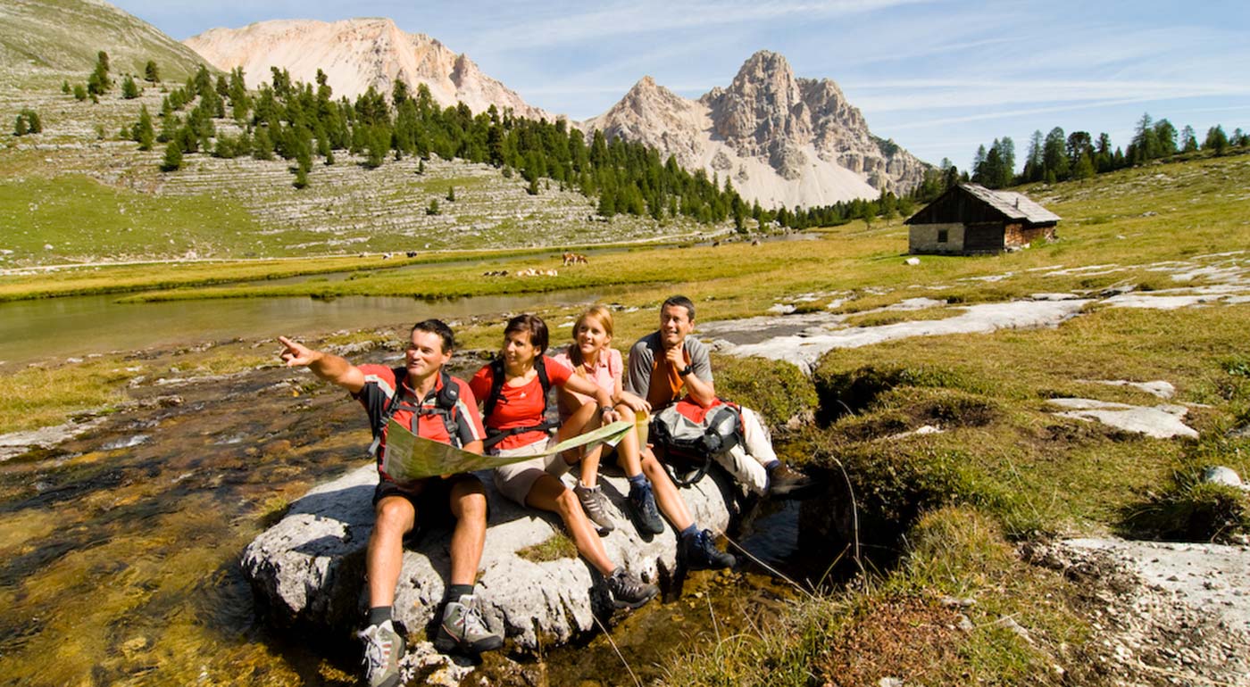 Wanderer ruhen sich auf einem Stein mitten auf einer Wiese aus