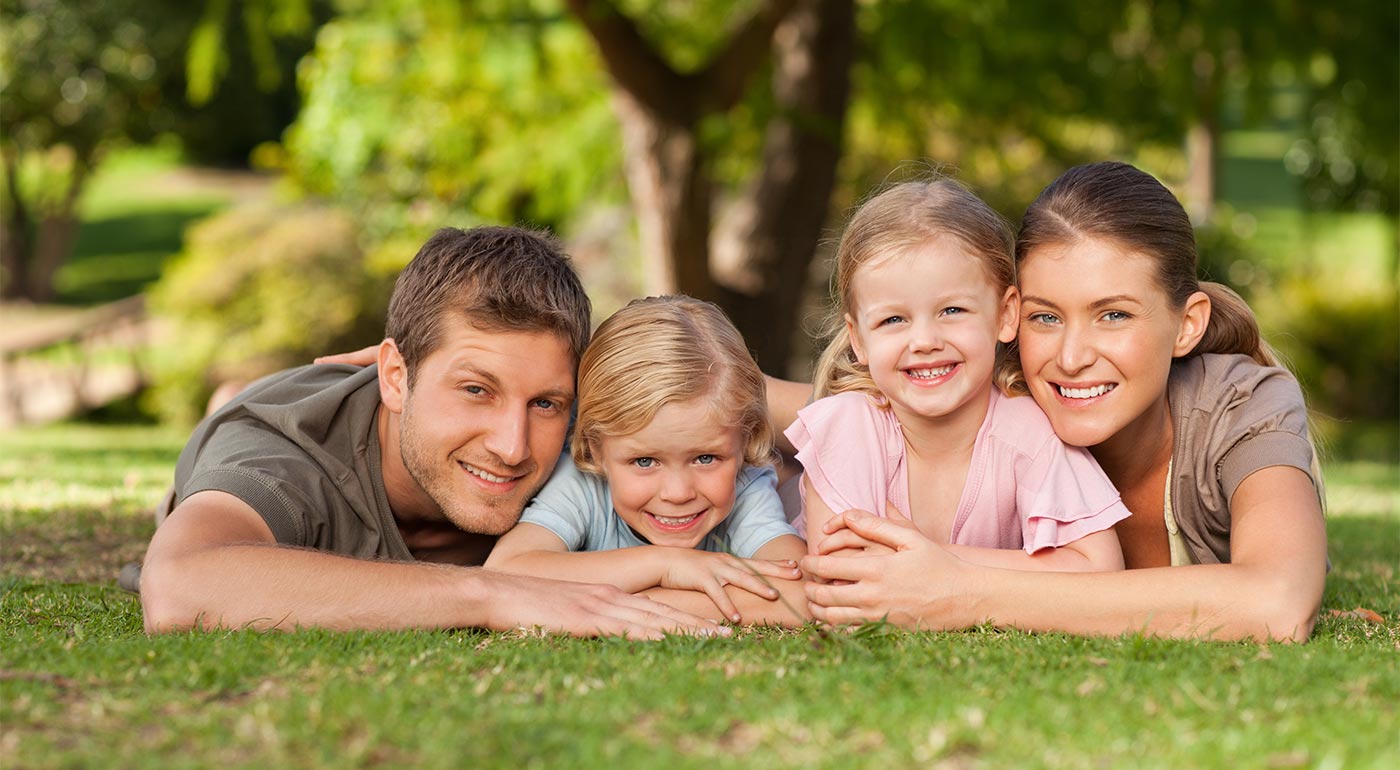 Eine glückliche Familie lacht auf einer Wiese