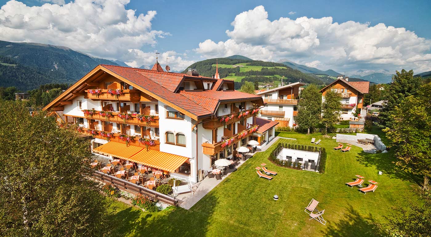 Exterior view of Hotel Markushof with lawn and terrace on a sunny day